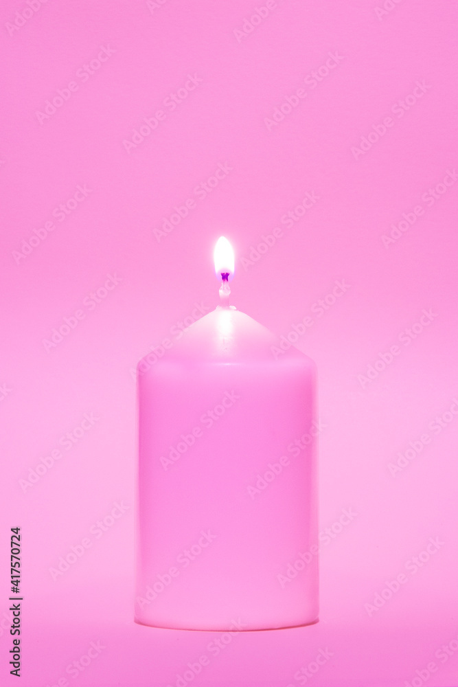 Coloured candle against a pink background Coloured candle against a pink background