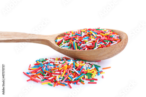 Colorful sprinkles and wooden spoon on white background. Confectionery decor