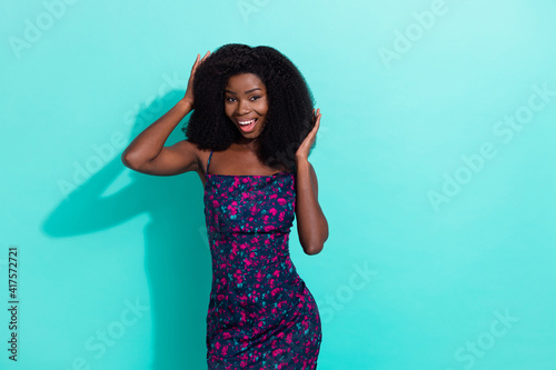 Photo portrait of happy woman touching hairstyle overjoyed pretty nice isolated on vivid teal color background