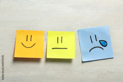 Stickers with drawn happy, sad and unemotional faces on light background, flat lay