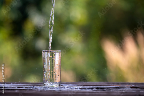 Glass of water are filled in descending order, on a light background, clean drinking water