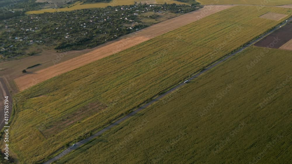 Drone video above spring countryside with agricultural fields, villages and road with cars. Agricultural landscape background.. Drone video above spring countryside with agricultural fields, villages and road with cars. Agricultural landscape background..