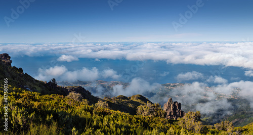 Above the clouds on a mountain trail. Colorful mist in valley. Trekking from Pico do Arieiro to Pico Ruivo, Madeira island, Portugal. 