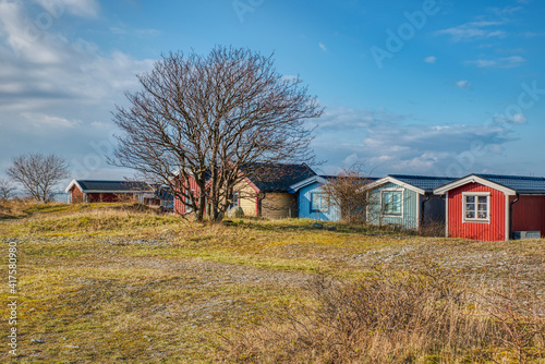 Backyard of colourful Swedish summerhouses shows a traditional, wealthy Swedish seaside village. Illustration of Nordic multi coloured summerhouse conveys the concept of typical Scandinavian lifestyle