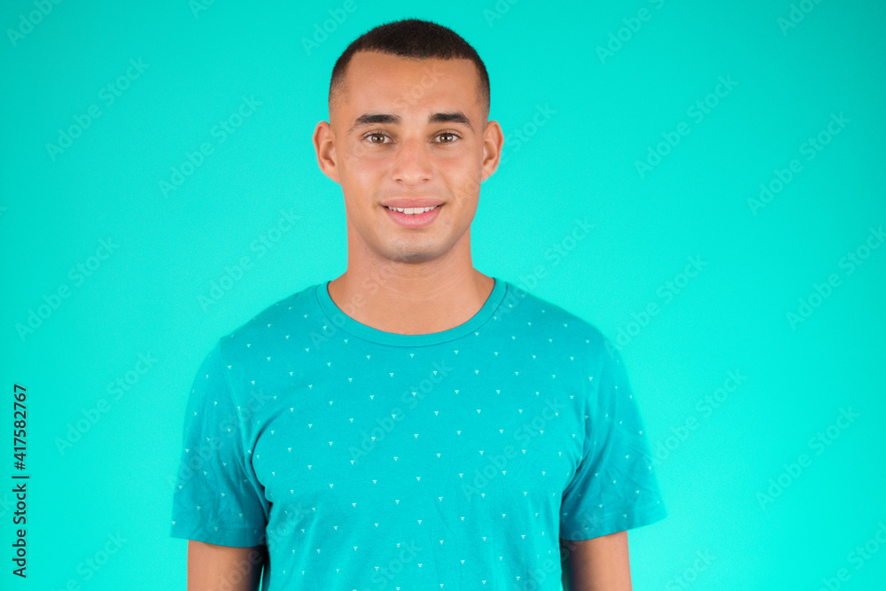Close up portrait of a handsome young latin man smiling over green background Close up portrait of a handsome young latin man smiling over green background