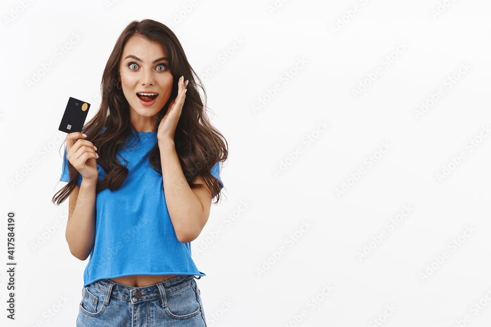 Excited and happy young woman react to huge sale, big discounts in store, grab her credit card and rush shopping, smiling amazed, love waste money, standing white background rejoicing Excited and happy young woman react to huge sale, big discounts in store, grab her credit card and rush shopping, smiling amazed, love waste money, standing white background rejoicing