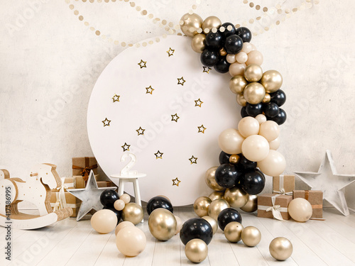 Birthday decorations - gifts, toys, balloons, garland and number for little baby party on a white wall background.