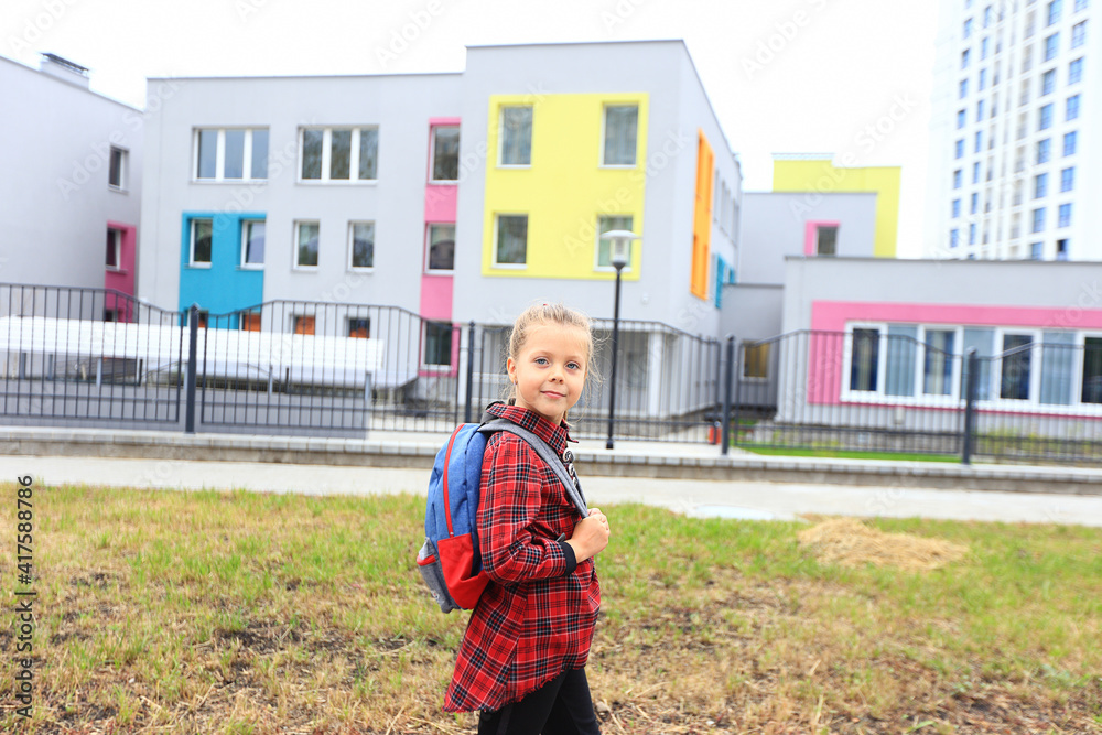 A girl in a school uniform with a backpack on her shoulders goes to school. A girl in a school uniform with a backpack on her shoulders goes to school.