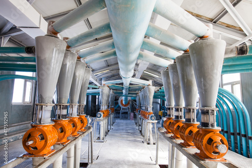 Aktobe region, Kazakhstan - May 06, 2012: Wheat flour production line. Electric motors with cone hoppers and grain mills.