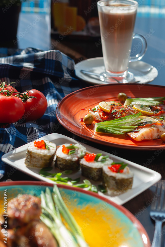 Appetizing homemade sushi rolls on the table in a beautiful setting, sunny lighting