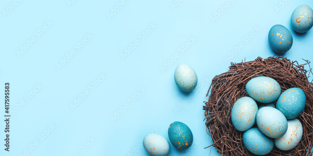 Easter eggs in nest on blue background. Flat lay, top view. Stock Photo ...