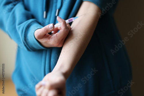Woman making herself intravenous drug injection closeup. Heroin addiction concept