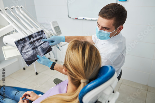 Dentist giving explanations about the teeth condition on x-ray