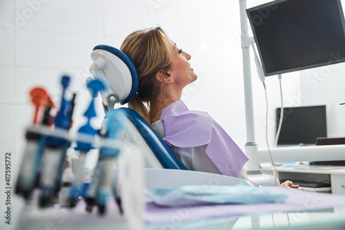 Female sitting in dental chair before the monitor display