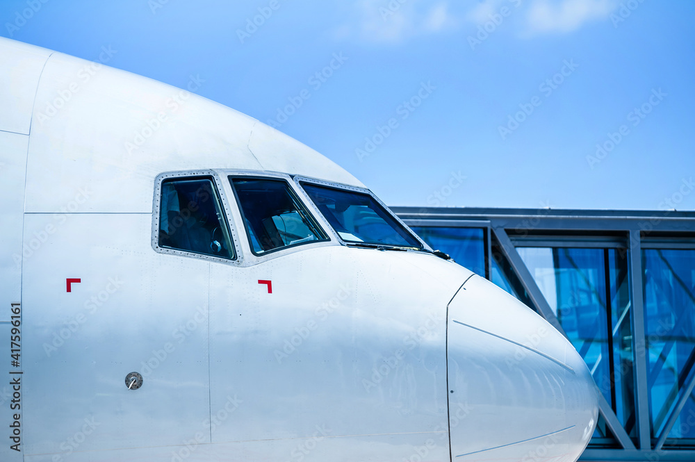 nose of airplane with boarding bridge