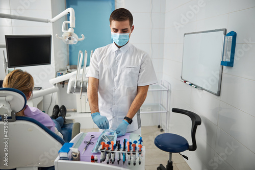 Focused dentist getting tray with tools out of bag
