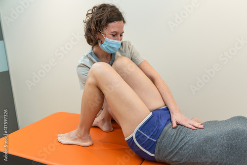 Картината върху платно Physiotherapist and patient in Global Postural Re-education session, with pandemic protection mask