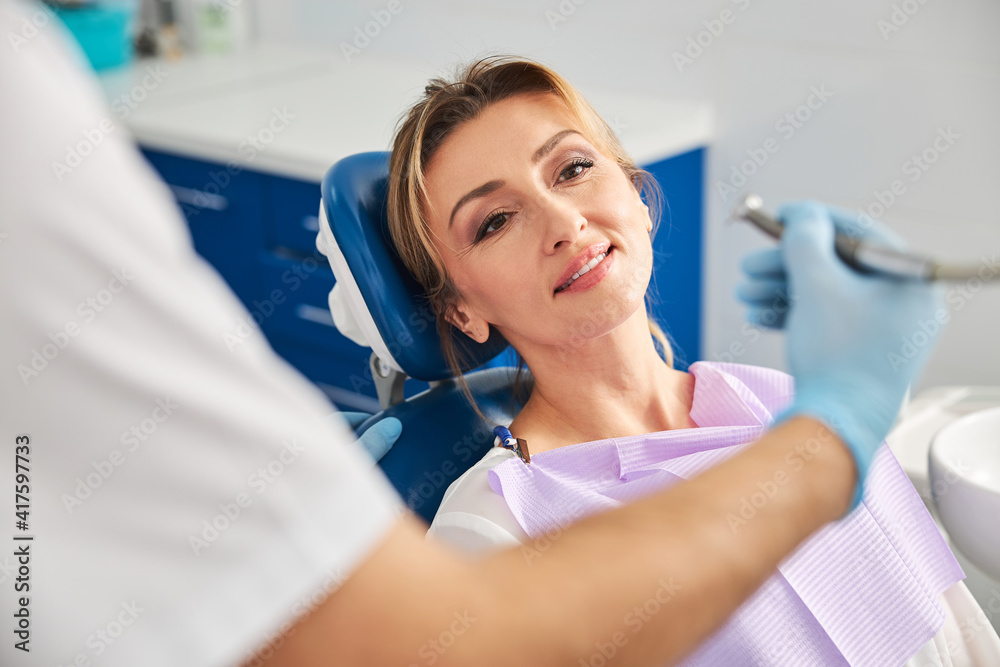 Fototapeta premium Relaxed woman waiting for the start of teeth drilling