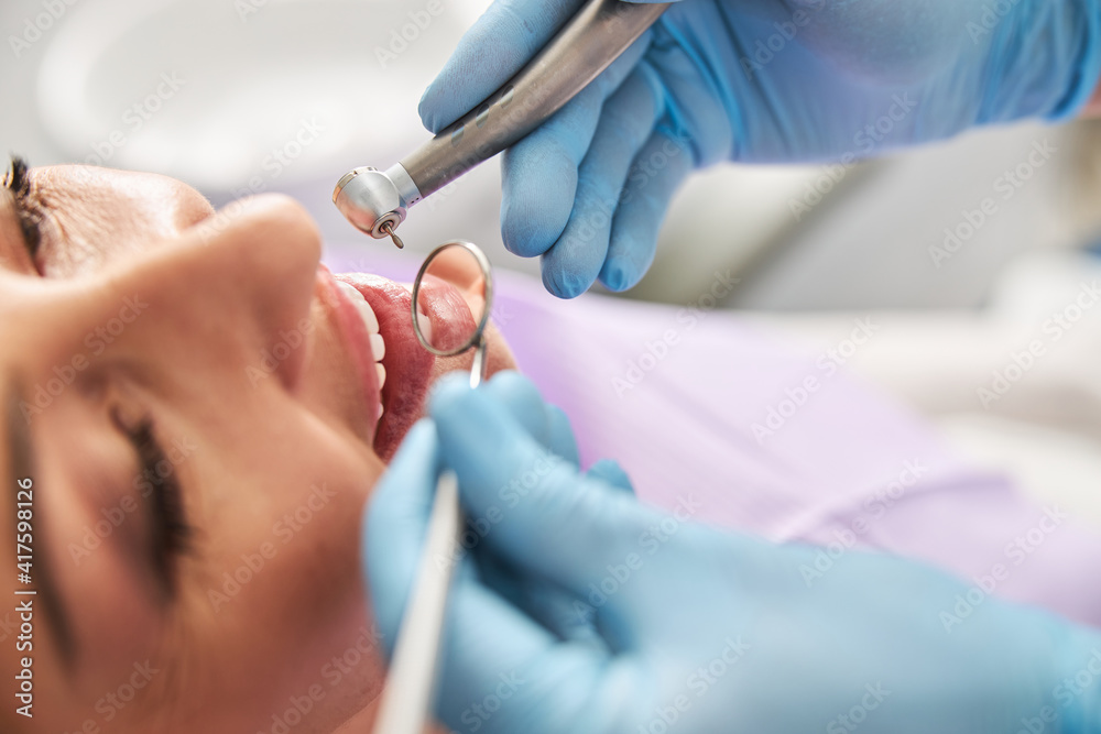 Naklejka premium Medical specialist zooming on teeth with mouth mirror