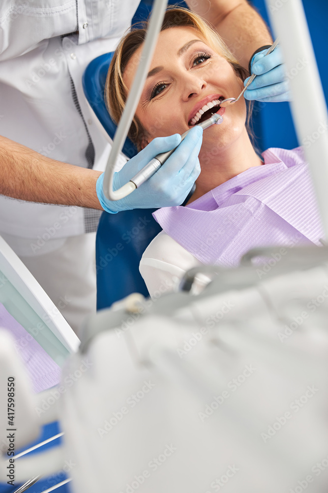 Delighted pretty young woman during dental operation Delighted pretty young woman during dental operation