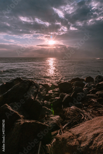 Zachód słońca nad oceanem i skalistym wybrzeżem. photo