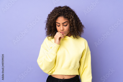 Young African American woman isolated on background having doubts