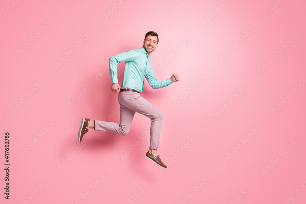 Full body profile side photo of attractive man happy shopping run empty space jump up isolated on pink color background Full body profile side photo of attractive man happy shopping run empty space jump up isolated on pink color background