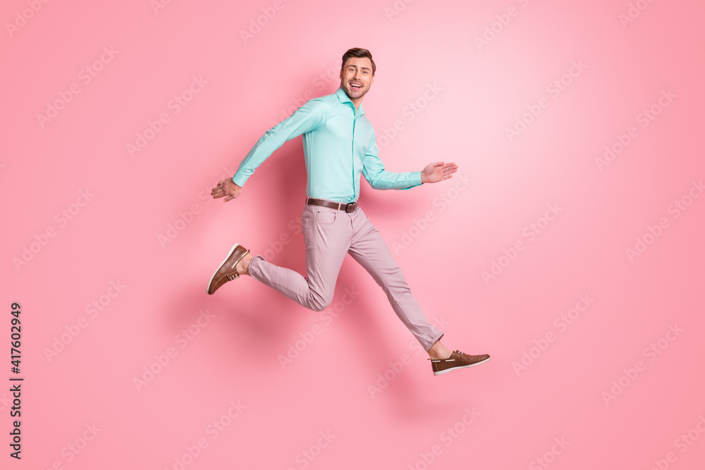 Full length profile side photo of happy cool man run jump air copyspace wear brown shoes isolated on pink color background