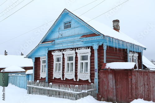 Vintage wooden rural house in Dunilovo village in Ivanovo region, Russia. Building facade; ornamental windows with carved frames. Russian traditional national folk style in architecture. Countryside photo