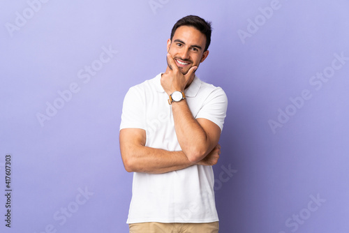 Young handsome man isolated on purple background happy and smiling