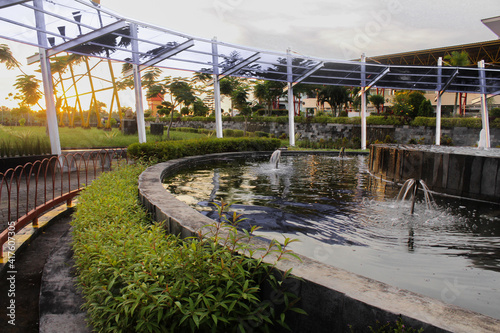 fountains and vegetation around it. Sunset background concept