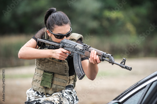 Military female soldiers in action tactical combat shooting from rifle machine gun. Shooting and weapons. Outdoor shooting range