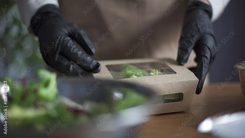 Woman preparing delivery food inside takeaway restaurant