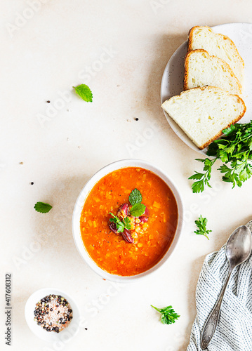 Hot and spicy, thick lentil and red bean soup with canned tomatoes and coriander. Concrete background. Top view.