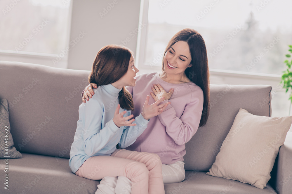 Photo of optimistic brunette red hairdo mom daughter sit talk on sofa wear sweater pants at home Photo of optimistic brunette red hairdo mom daughter sit talk on sofa wear sweater pants at home