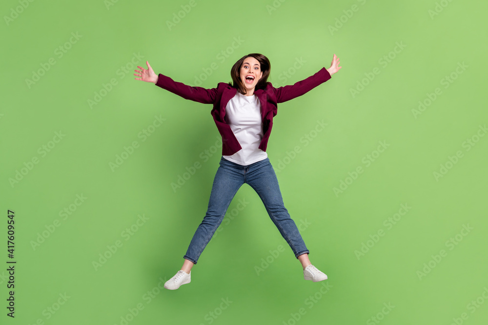 Full size photo of optimistic brown hairdo lady jump wear cardigan jeans sneakers isolated on green background