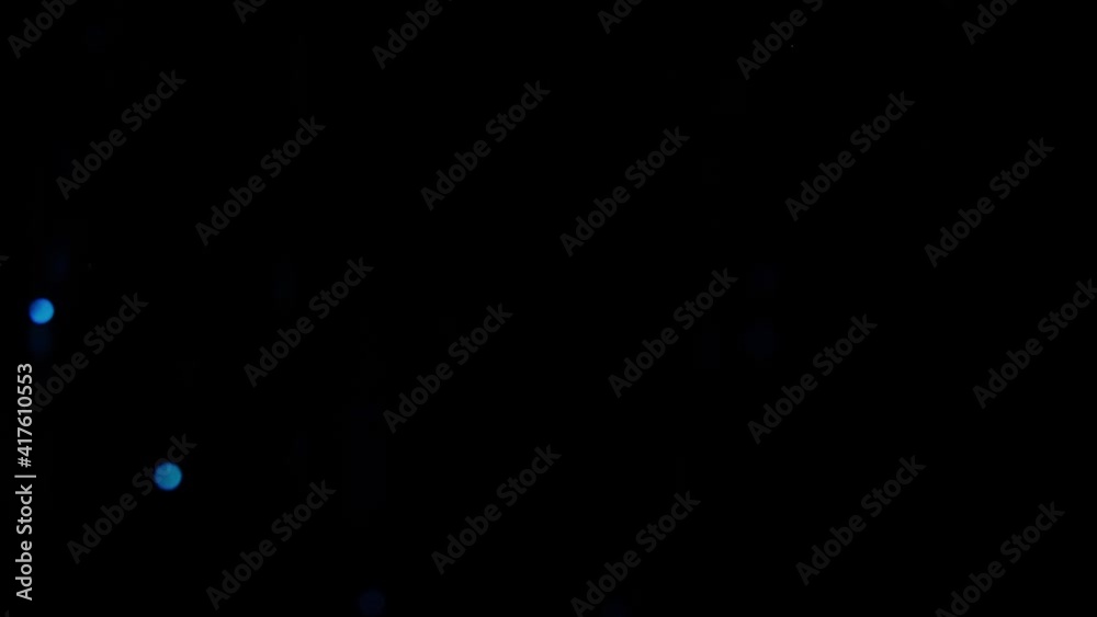 Slow motion video of Blue shining glitter particles background. Glowing light particles fall. Falling Glitter Background in Super Slow Motion.