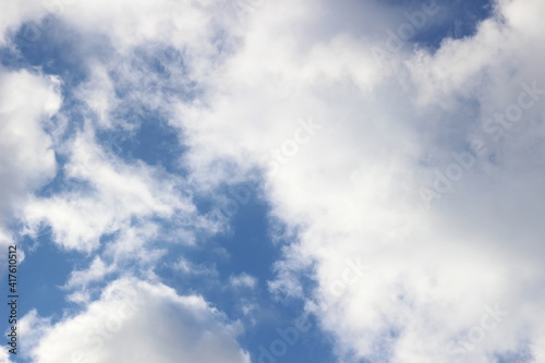 Bright March blue sky with white and gray clouds in sun light