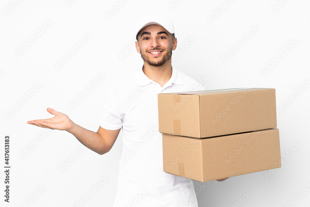 Delivery Arabian man isolated on blue background holding copyspace imaginary on the palm Delivery Arabian man isolated on blue background holding copyspace imaginary on the palm