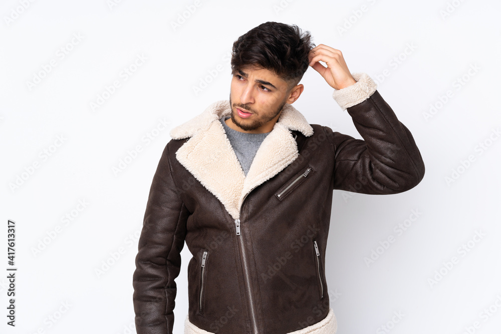Arabian handsome man over isolated background having doubts while scratching head Arabian handsome man over isolated background having doubts while scratching head