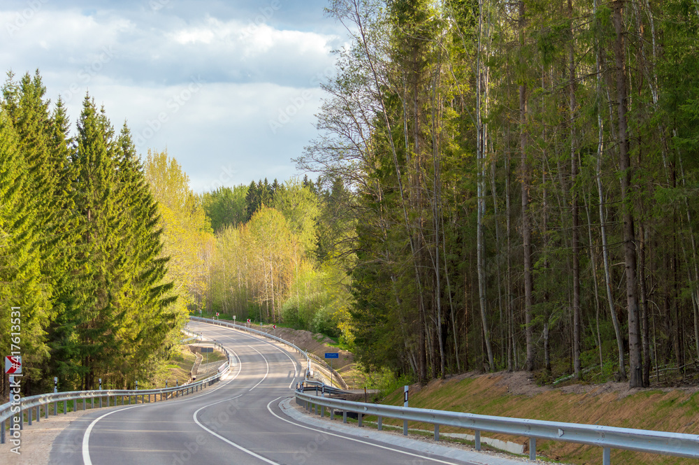 Fototapeta premium Winding road down the hill in spring.