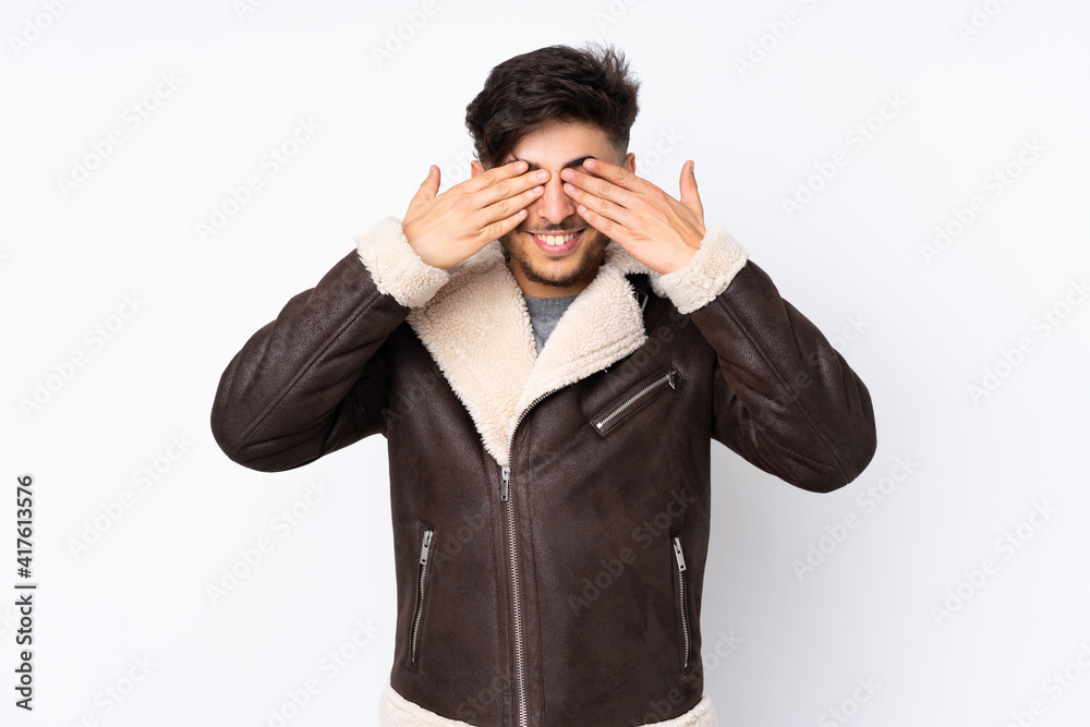 Arabian handsome man over isolated background covering eyes by hands and smiling Arabian handsome man over isolated background covering eyes by hands and smiling