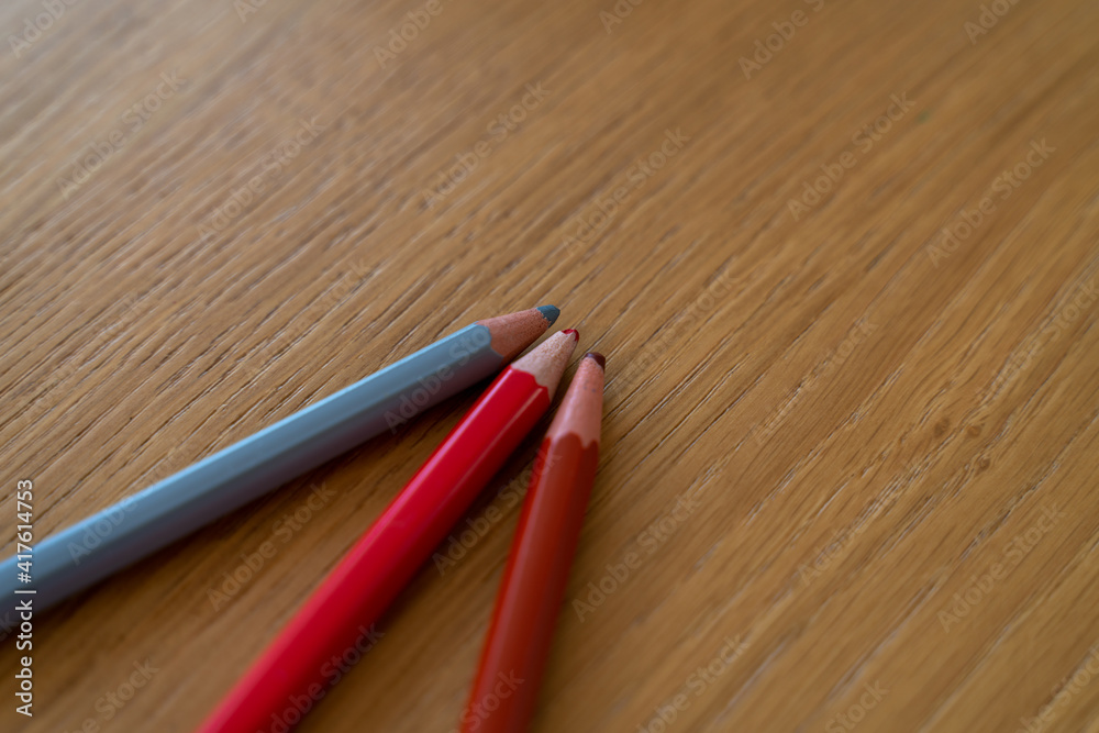 Obraz premium Trois crayons de couleur sur une table en bois clair