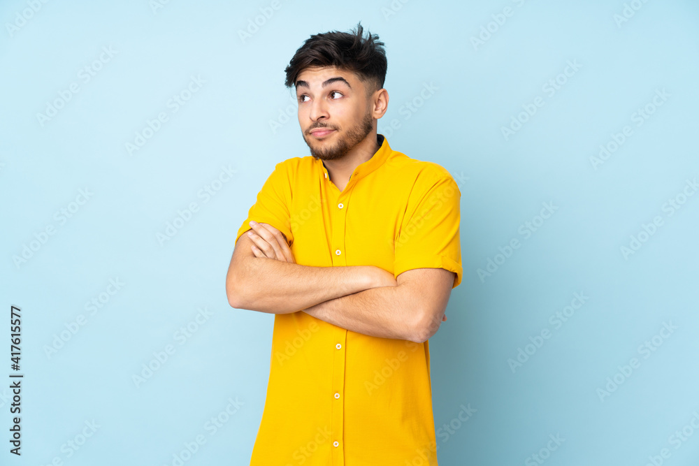 Arabian handsome man over isolated background making doubts gesture while lifting the shoulders Arabian handsome man over isolated background making doubts gesture while lifting the shoulders
