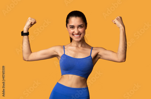 Happy sporty woman celebrating success gesturing at studio