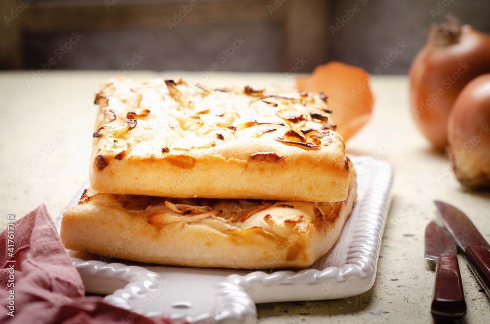 Italian focaccia bread with onions on white ceramic tray. Italian focaccia bread with onions on white ceramic tray.