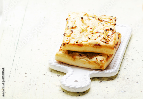 Italian focaccia bread with onions  on white ceramic tray. photo