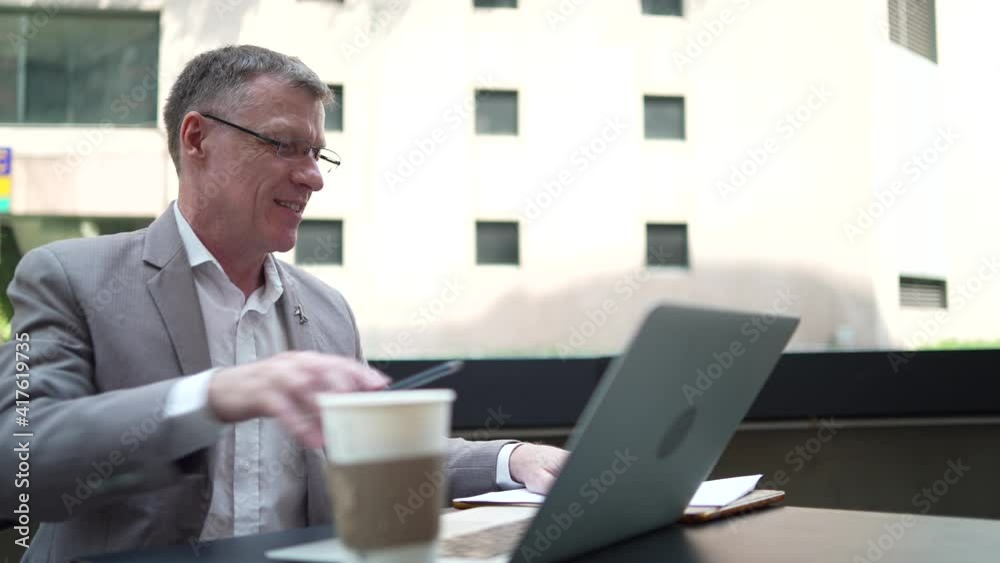 businessman drinking coffee and working business with online community by laptop. day starting at coffee cafe for working success, professional business worker in suit, shot slow-motion