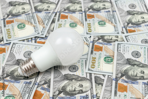 Energy Efficient Light Bulb on money background. Energy saving concept