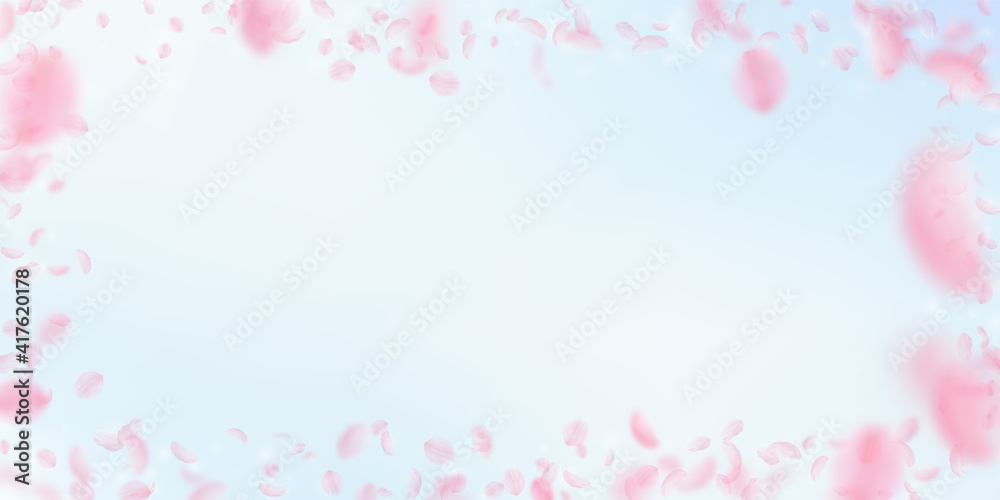 Sakura petals falling down. Romantic pink flowers frame. Flying petals on blue sky wide background.